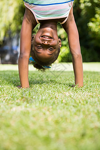 一个可爱的混种女孩的肖像 微笑 做一个头目乐趣娱乐性娱乐绿色公园休闲服童年天空农村黑色草原高清图片素材