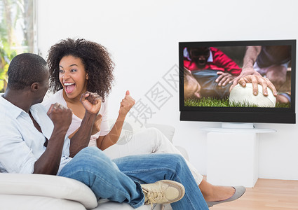 情侣行动毛笔字在电视上看橄榄球比赛时欢呼一对情侣背景