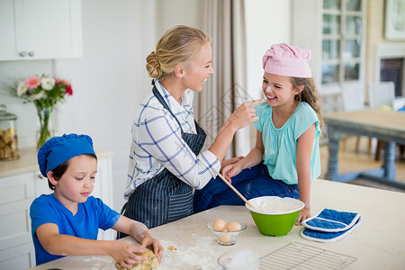 母亲和孩子在厨房挣钱时玩得开心高清图片