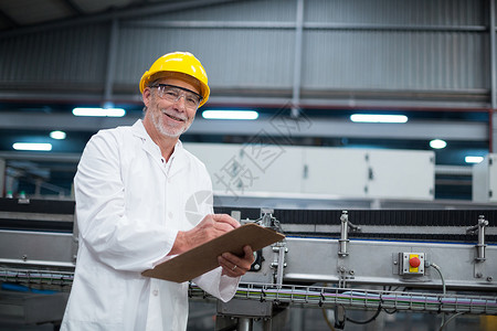 高级工程师证书微笑的工厂工程师在工厂的剪贴板上维护记录工作商业快乐男人电脑生产线制造防护眼镜职业平板背景