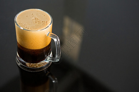 玻璃桌上的黑啤酒现实泡沫茶点反射啤酒智力啤酒杯饮料头饰社交背景图片