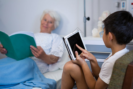 高级病人阅读书籍 男孩使用数字平板电脑女性病床笔记本医学病号女士互联网器材长椅老年智力高清图片素材
