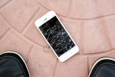 顶视图损坏的电话服务裂缝商业展示玻璃手机破坏碎屏技术地面鞋高清图片素材