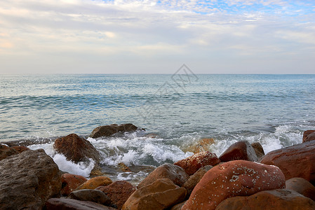 海洋中的岩石卵石海岸飞溅泡沫状碎石海岸线矿物高清图片