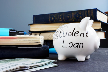 学生贷款写在小猪银行和钱上储蓄高清图片素材