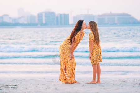 美丽的母亲和女儿在海滩上享受暑假的快乐女孩妈妈热带家庭海洋日落女士城市孩子乐趣水高清图片素材