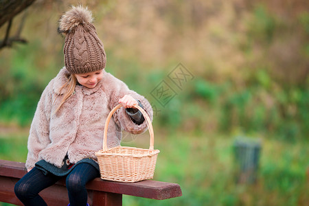 秋天户外带篮子的可爱小姑娘幸福公园喜悦快乐微笑森林女性外套孩子橙子白种人高清图片素材