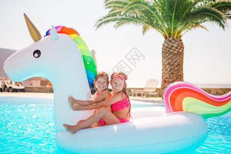 游泳玩耍两个小孩在游泳池里玩耍呢太阳镜享受假期幸福游泳衣姐姐太阳女孩孩子青年背景
