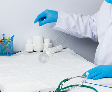 身穿白色医疗大衣的医生坐在一张桌子上健康高清图片素材