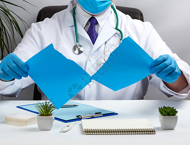 身穿白色医疗大衣的医生坐在棕色的桌子上药物保健护士处方男人文档临床卫生诊所工作室职业高清图片素材