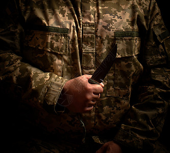 身穿军服的士兵拿着一把尖利战术刀背景图片