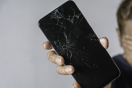 手机裂缝素材手持灰色背面智能电话触摸屏幕破碎的妇女女士网络破坏触摸屏裂缝维修粉碎展示玻璃事故背景