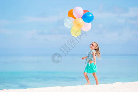 海滩女孩红气球可爱的小女孩在沙滩玩气球游戏喜悦自由女孩天空童年飞行海滩学校孩子情感背景