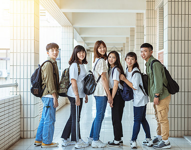 欢乐学生群体 在大学的走廊上站着女士女孩男生团队团体青年校园背包快乐学校背景图片