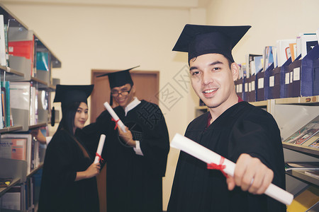 持有毕业证书的快乐研究生手头有文凭 教育学士学位证书男性幸福微笑男人大学帽子成就成人学生程度高清图片素材