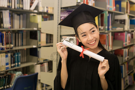 持有毕业证书的快乐研究生手头有文凭 教育学士学位成就女士大学学校微笑女性帽子学习幸福学生高清图片素材