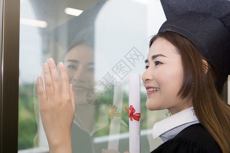 持有毕业证书的快乐研究生手头有文凭 教育学士学位女士微笑学习幸福帽子学校大学女性成就户外高清图片素材
