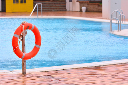 悬在游泳池附近的橙色生命浮标背景图片