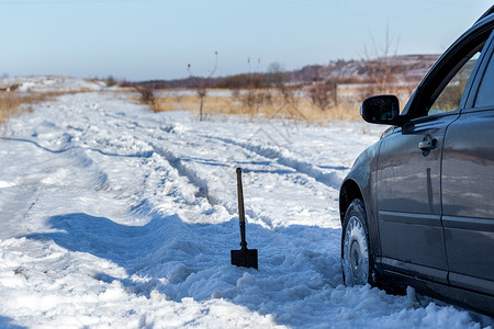 铲子车用铲子和有选择性的焦点在白天被困在雪地上车辆旅游越野事故压力陷阱季节打扫帮助风暴背景