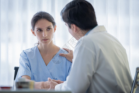 医生照顾一位有病的 伤痛和忧伤的妇女诊断专家咨询悲伤帮助保健实验室医师桌子男人疾病高清图片素材