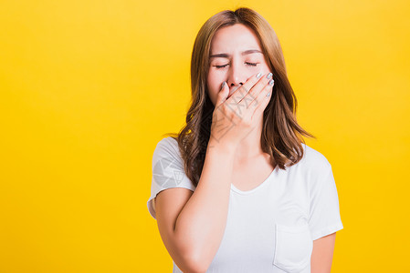 妇女疲倦的情绪 困睡着她紧闭的嘴张着女士女性黑发黄色白色工作室头发女孩困倦青少年伸展高清图片素材