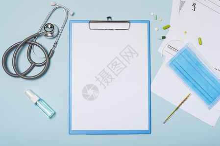 医疗画册设备封面图片医疗设备模拟剪贴板 配有听诊器和药物 蓝色复制空间背景的外科面具背景