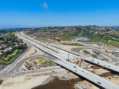 发展阶段在小河上建造高速公路桥梁的空中观察图景安全工人电缆卡车基础设施交通运输进步木头沥青背景