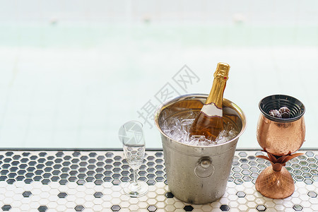 桶里拖布冰桶里有香槟瓶子 还有浴池附近的两个杯子蜜月玻璃游泳池冷却器夫妻水池奢华旅行泡酒假期背景