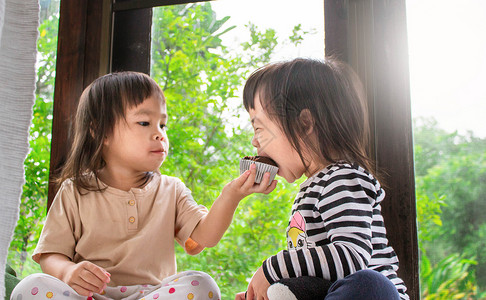亚洲小女孩和妹妹 正在房间里吃香蕉蛋糕 很好吃 笑声  谢谢孩子们面包女孩巧克力香蕉食物家庭孩子童年早餐快乐的高清图片素材