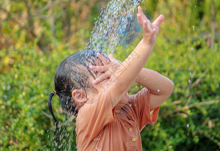 可爱的亚洲小女孩玩得开心 在夏令营里玩水喷水管公园童年晴天浴缸后院家庭洒水器飞溅行动乐趣小的高清图片素材
