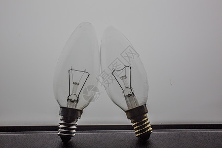 闪光玻璃灯泡 以落放形状灯光金属灯丝玻璃插座背景图片