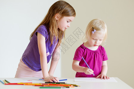 两个小姐妹 用彩色的铅笔画画乐趣学习女孩蜡笔幼儿园染色孩子姐姐艺术兄弟课高清图片素材
