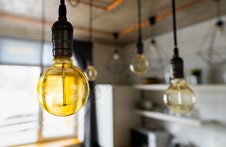 挂在现代厨房里的大老式白炽灯泡 低效的灯丝灯泡浪费电力 带直线的装饰古董爱迪生灯泡 可调光 暖白色 E27老的高清图片素材