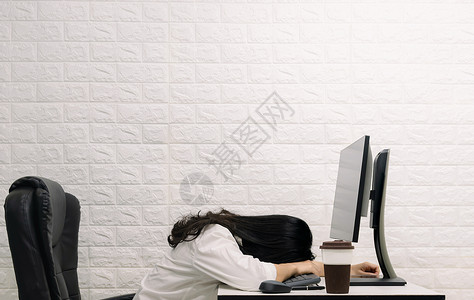 一个女人睡在桌上的电脑屏幕上高清图片