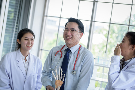 亚洲老师教学生理科和解剖学的亚洲教师男性学校科学颅骨男人班级身体教育药品骨骼教授高清图片素材