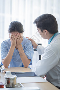 医生照顾一位有病的 伤痛和忧伤的妇女医师医院男人诊断蓝色女士治疗考试从业者药品疾病高清图片素材