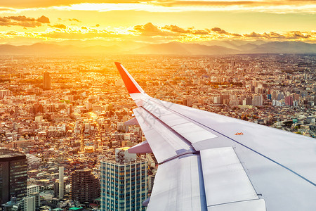 飞机机窗空机窗口中的日本城景视图景观运输旅游日落太阳航天喷射商业高度技术背景