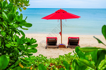华欣海滩红伞在沙滩上晴天闲暇旅行夫妻海洋热带地平线休息躺椅椅子背景