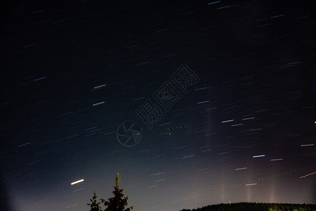 蓝夜天空有星星绿色天篷宇宙云带天体地球科学蓝色树木地平线背景图片