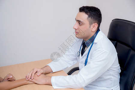友善的男医生手握着病人手 坐在De疼痛癌症讲话医院邮件情感女性女士桌子疾病同情高清图片素材