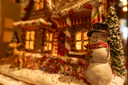 圣诞手杖糖姜饼闪闪发光的雪人 在姜饼屋前背景
