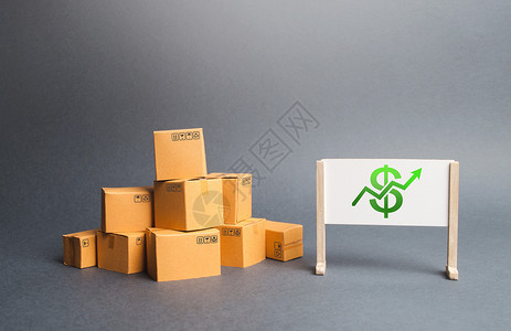 一堆纸板箱和白板 上面有美元符号和绿色向上箭头 生产的增长率 消费需求增加 商品销售收入增长 价格上涨背景