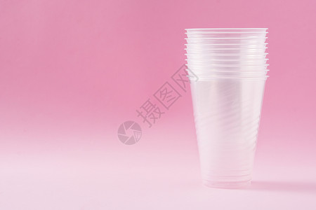 粉红背景的可处置废塑料杯生日工业生态餐具粉色杯子回收用具垃圾白色背景图片