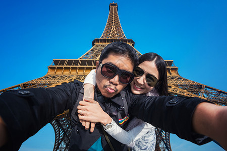 年轻夫妇旅游者在Eiffel T附近使用移动电话的自拍女士蜜月情侣女孩旅游工具男朋友女朋友异性电话快乐的高清图片素材