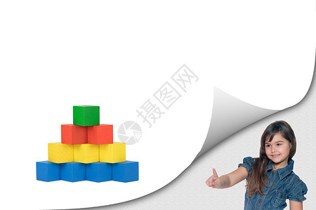 小女孩指着木制立方体玩具背景图片