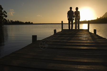 一对夫妇站在湖边靠岸 握着手后视线两个人假期乡村中年人男人夫妻日落女士场景天空背景图片