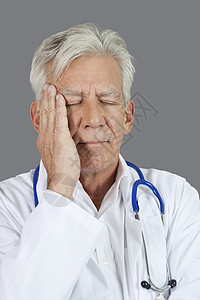 高级医生因灰色背景头痛而患头痛医疗的高清图片素材