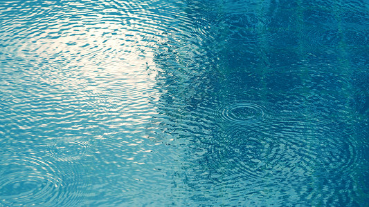 游泳池表面的雨滴白色蓝色涟漪池塘圆圈水坑下雨人行道街道波纹背景图片