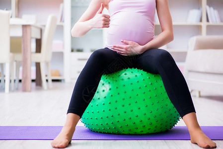 瑜伽瑞士球孕妇在预产期分娩时行使身体权利微笑健康女士女孩肚子练习婴儿母性活动腹部背景
