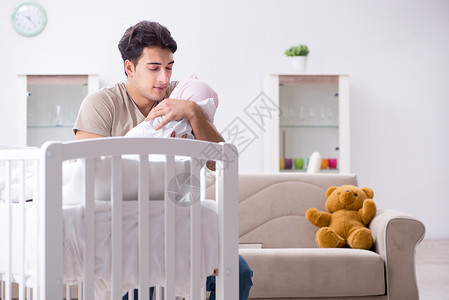 莫负时光年青父亲在家与新生婴儿共度时光爸爸男人房间孩子女孩父母婴儿床关系感情母性背景